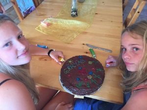 Mädchen verzieren einen Kuchen