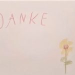 Kinderzeichnung einer gelben Blume mit dem Wort Danke in Großbuchstaben