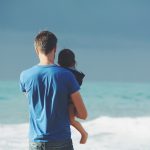 Vater mit Kind im Urlaub am Meer